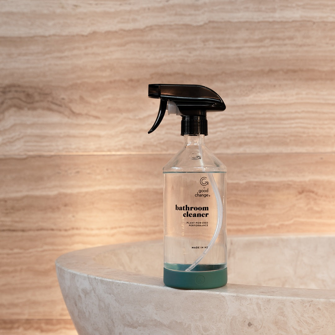 Bottle of bathroom cleaner on a stone surface with wooden wall background