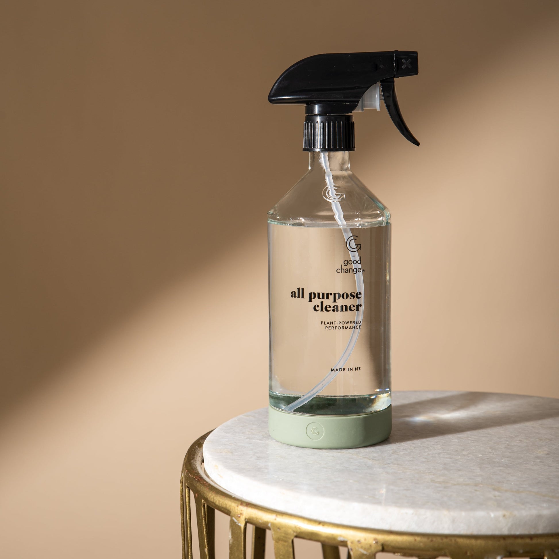 All-purpose cleaner bottle on a marble surface with a beige background